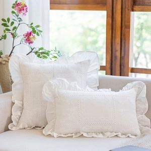 Detail of white cotton pillowcase with lace embroidery and elegant ruffle edges