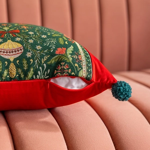 Dettaglio copricuscino natalizio con motivo jacquard, velluto rosso e cerniera invisibile