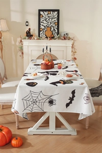 Detailed pattern of Halloween tablecloth with black bats, orange pumpkins and spiders