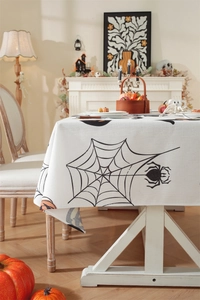 Close-up of Halloween tablecloth with spider and pumpkin prints in a cozy home setting