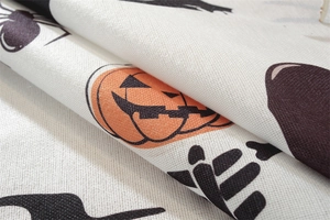 Macro detail of polyester fabric showing festive orange pumpkins and black spider prints