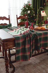 Detail of Christmas table runner with red-green plaid pattern and woven tree motif
