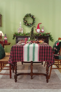 Close-up of red plaid table runner with Christmas tree patterns on textured fabric