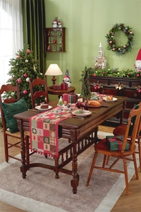 Detailed view of red and green plaid Christmas table runner with festive pom-pom tassels