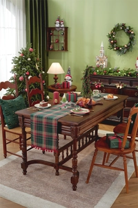 Close-up of red and green plaid Christmas table runner with festive pom pom trim