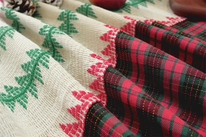 Detail of Christmas table runner featuring knitted tree pattern and red tartan plaid edge