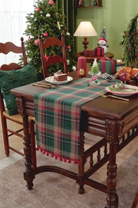 Close-up of Christmas table runner with red pompoms and classic green red plaid pattern