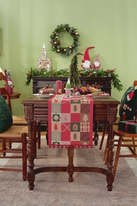 Detail of Christmas table runner with festive tree patterns and red pompom fringe