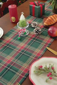 Close-up of red and green tartan Christmas table runner on a festive wooden dinner table