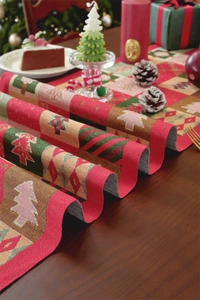 Detail of Christmas tree jacquard table runner with red and green plaid patterns