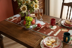 Close-up of a festive Christmas table runner with snowman and gingerbread man patterns