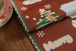 Macro view of woven Christmas table runner with gingerbread and snowman patterns
