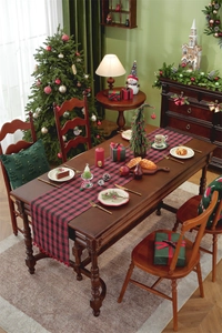 Close-up of red and black checkered table runner with small red pom-poms for Christmas