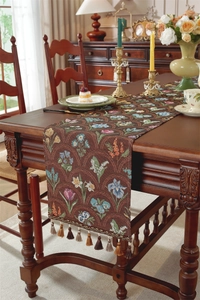 Détail d'un chemin de table vintage américain avec jacquard fleuri et pompons élégants