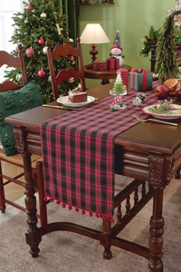 Close-up of red and black buffalo plaid Christmas table runner with soft pom-pom fringe