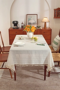 Detail of French linen style tablecloth featuring white stripes and tassel fringe texture