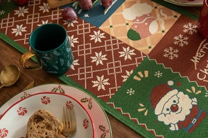 Close-up of woven Christmas table runner with festive Santa and snowflake patterns