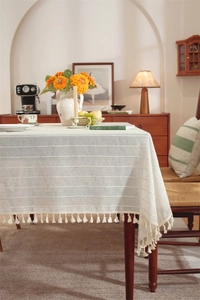 Detailed close-up of French faux linen tablecloth with striped texture and beige tassels