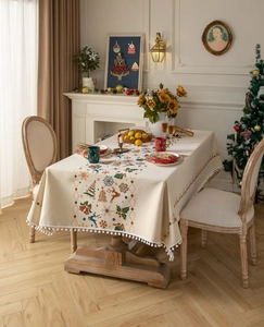 Detail of Christmas tablecloth with reindeer patterns and white pom pom tassel edges