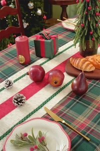 Detail of knit Christmas table runner with red stripes and green crochet lace edges