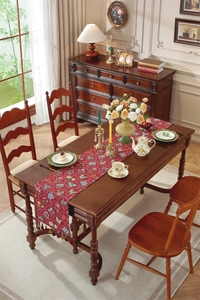 Détail du chemin de table vintage rouge avec tissage jacquard fleuri et glands
