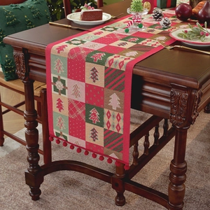 Christmas tree plaid table runner with red pom-poms and festive geometric patterns