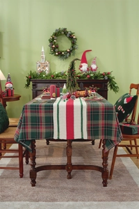 Detail of Christmas plaid table runner and green tablecloth on wooden festive dining table