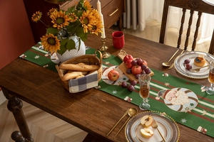 Detailed close-up of green woven Christmas table runner with Santa and snowflake motifs
