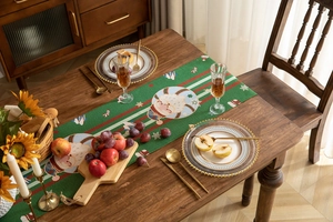 Detailed view of jacquard Christmas table runner with Santa Claus and snowflake motifs