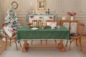 Christmas tablecloth in green with golden bells and snowflake prints and white pom pom fringe