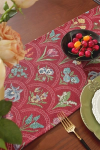 Gros plan du chemin de table jacquard rouge vintage aux motifs floraux tissés complexes