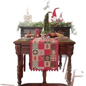 Christmas table runner with jacquard holiday patterns and festive red pompom fringe decor