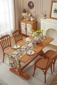 Exotic town architecture print table runner with decorative tassels on a wooden table