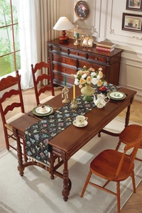 Détail du chemin de table vintage noir avec broderie florale et finitions à franges
