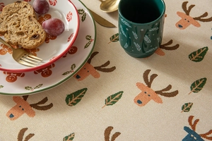 Detail of Christmas tablecloth showing woven reindeer and autumn leaf textures