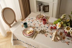 Close-up of Christmas tablecloth featuring reindeer prints and white pom pom fringe edges