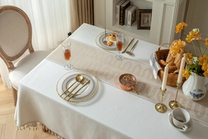 Close-up of geometric jacquard fabric weave and delicate fringe tassels on the tablecloth