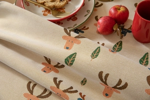 Detailed weave of jacquard Christmas tablecloth featuring reindeer and holiday patterns