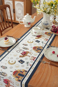 Detail of jacquard table runner with moon and camel pattern on a wooden table