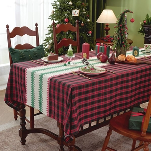 Red and black plaid Christmas table runner featuring festive green pine tree patterns