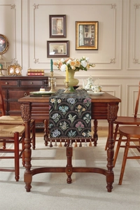 Gros plan du chemin de table en jacquard vintage avec des franges à glands métalliques