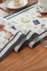 Macro detail of Eid table runner featuring golden moon and star embroidery on fabric