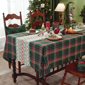 Christmas plaid tablecloth with white hollowed runner in a warm festive dining setting