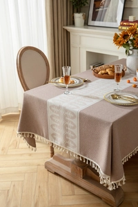 Detailed texture of Morandi pink jacquard tablecloth with white tassel edge and fringe