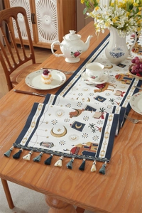 Close-up of blue tassel fringe and Middle Eastern camel motifs on a woven table runner
