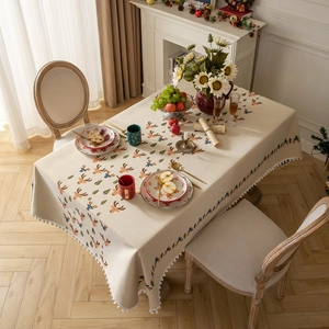 Christmas tablecloth with colorful reindeer pattern and white pom-pom trim for holiday decor