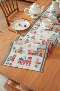Detailed woven table runner featuring colorful mosque patterns and elegant tassels on wood