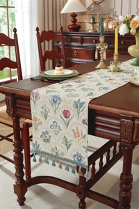 Détail de la texture jacquard florale avec des glands bleus et kaki sur un chemin de table