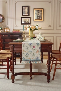 Gros plan du chemin de table vintage en jacquard avec de délicats pompons bleu clair