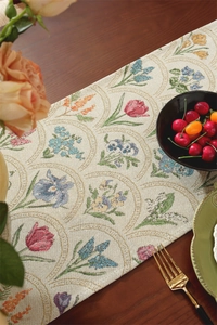 Gros plan d'un chemin de table jacquard floral vintage sur une table en bois foncé